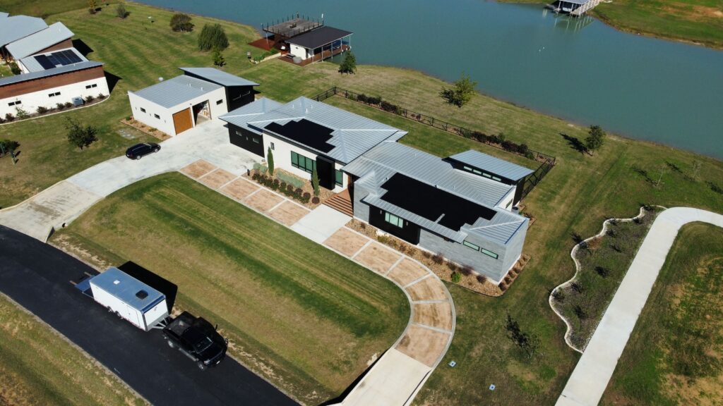 Standing-seam metal roof with integrated solar panels on a lakeside home in Martindale, Texas
