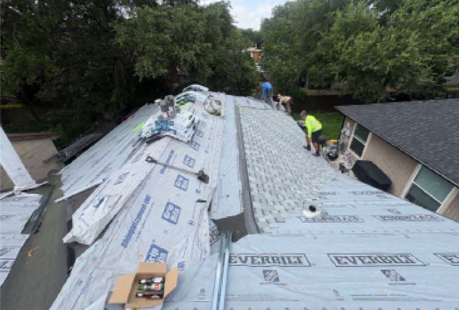 Roofing crew laying underlayment during a roof replacement