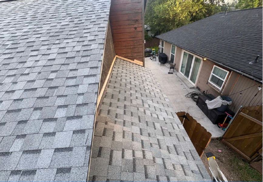 Finished roof replacement beside a wooden fence