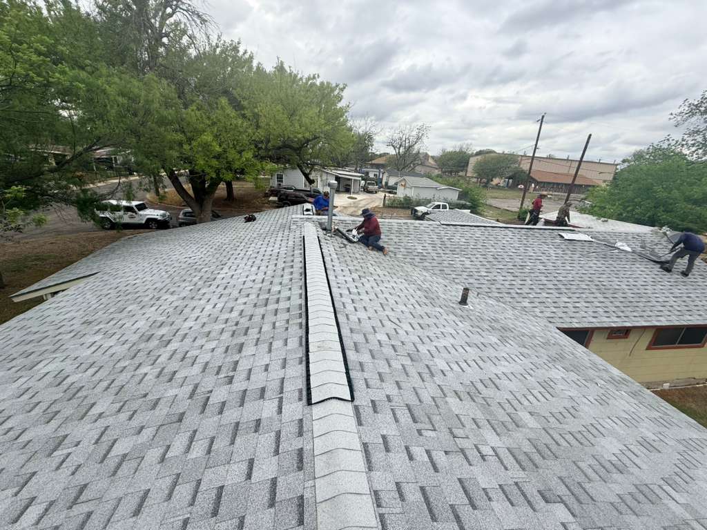 Roofing crew installing new shingles on a San Antonio home