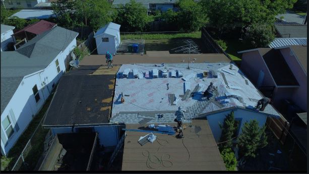 Aerial view of a roofio crew tearing off an old roof in San Antonio, Texas