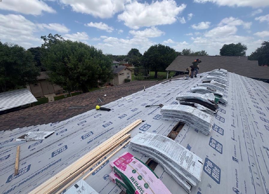 roofio crew installing protective underlayment over roof decking in San Antonio, Texas