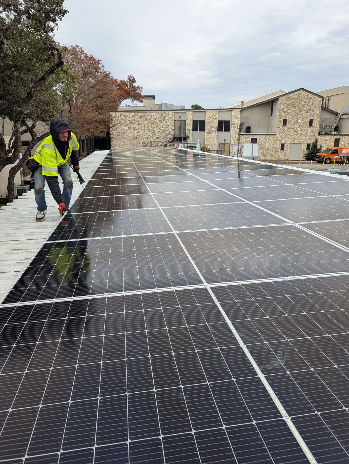 Roofio technician servicing a commercial solar array on a low-slope roof