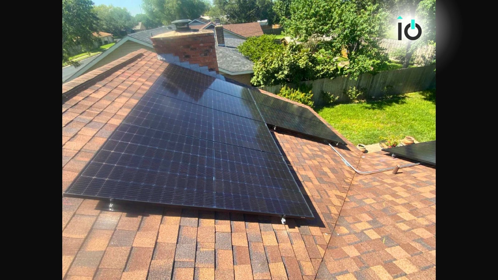 Aerial view of a rooftop solar array among trees