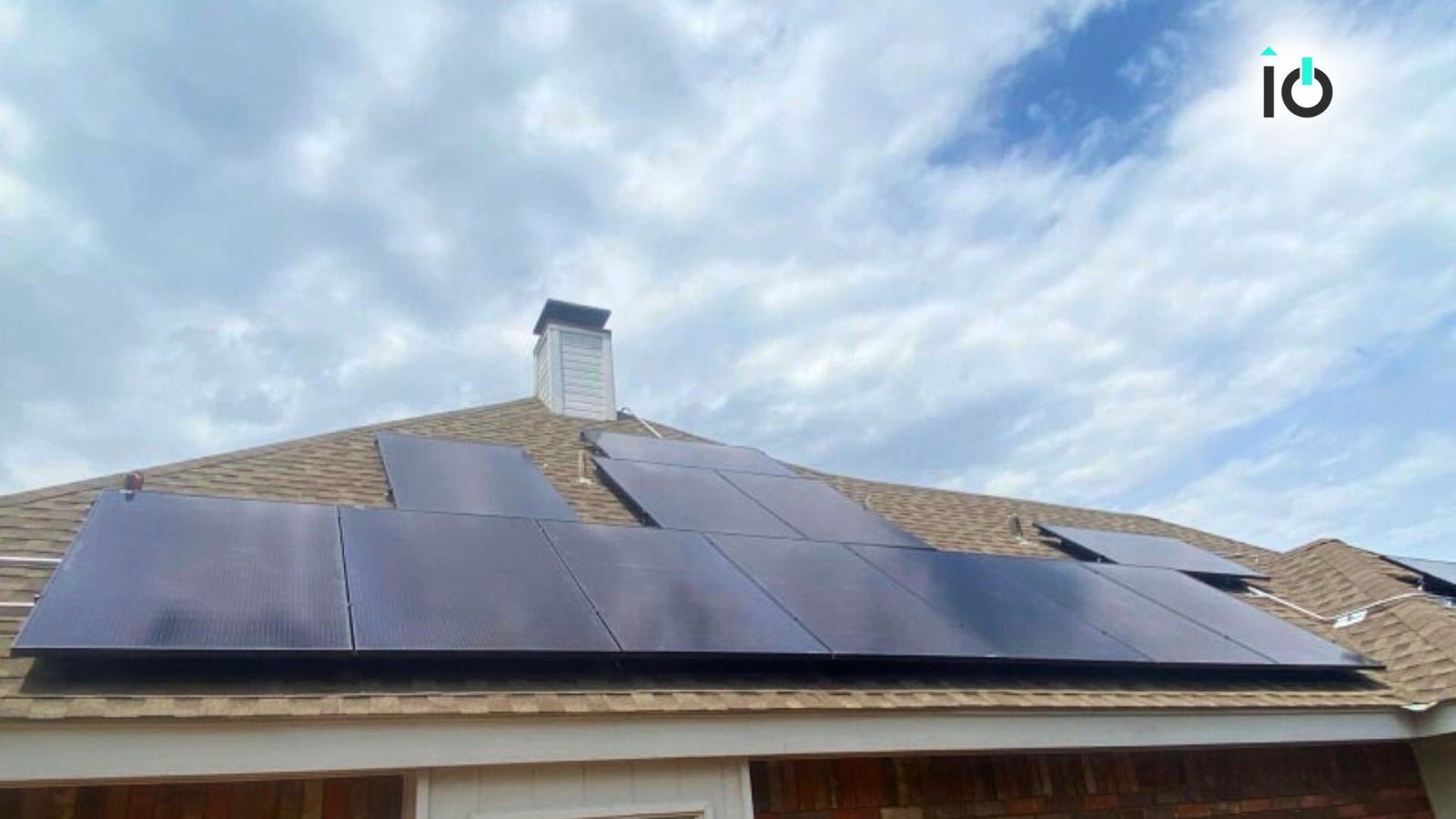 Solar panels on a roof beneath a clouded sky