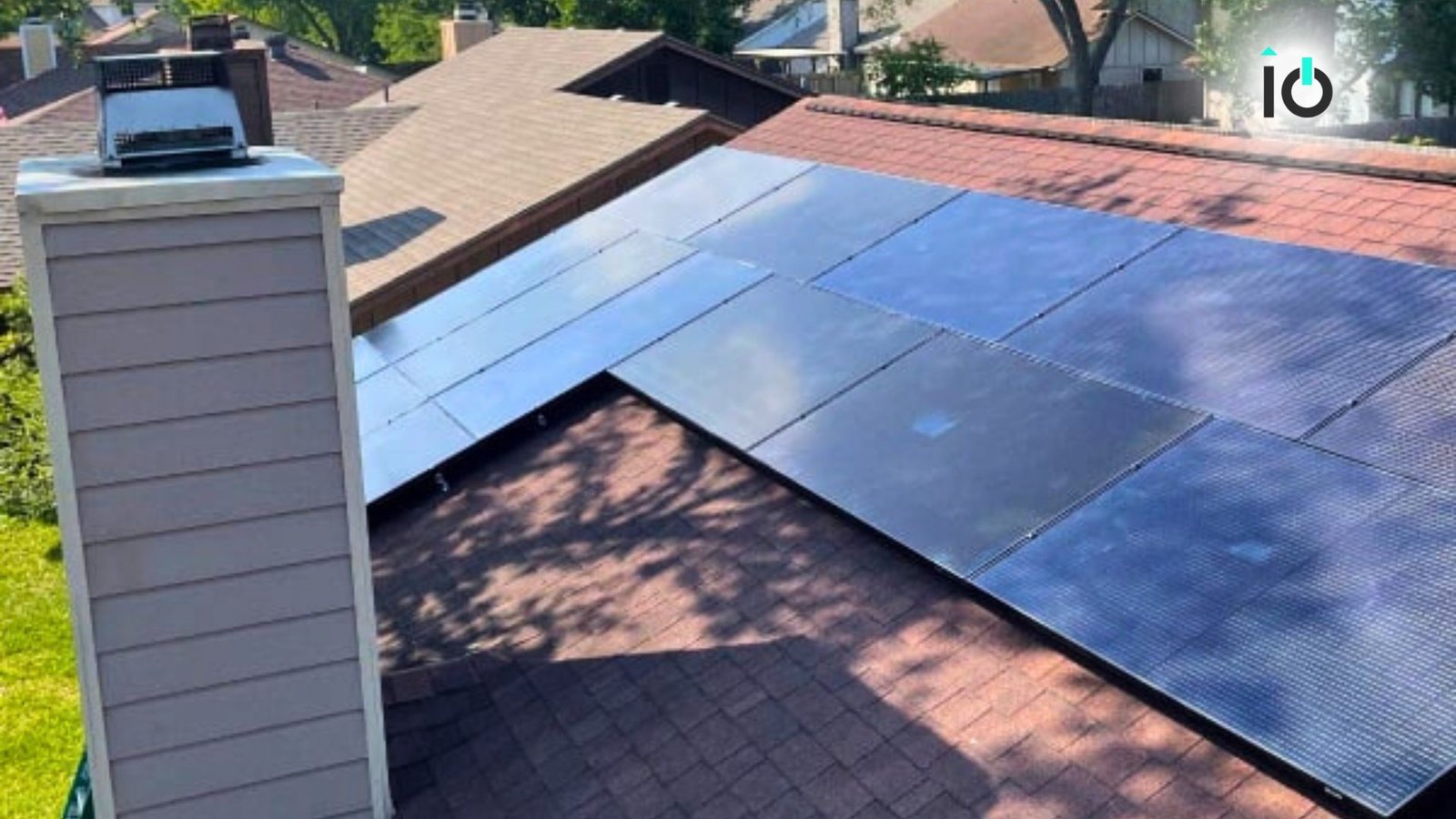 Solar panels spanning two roof planes beside a chimney