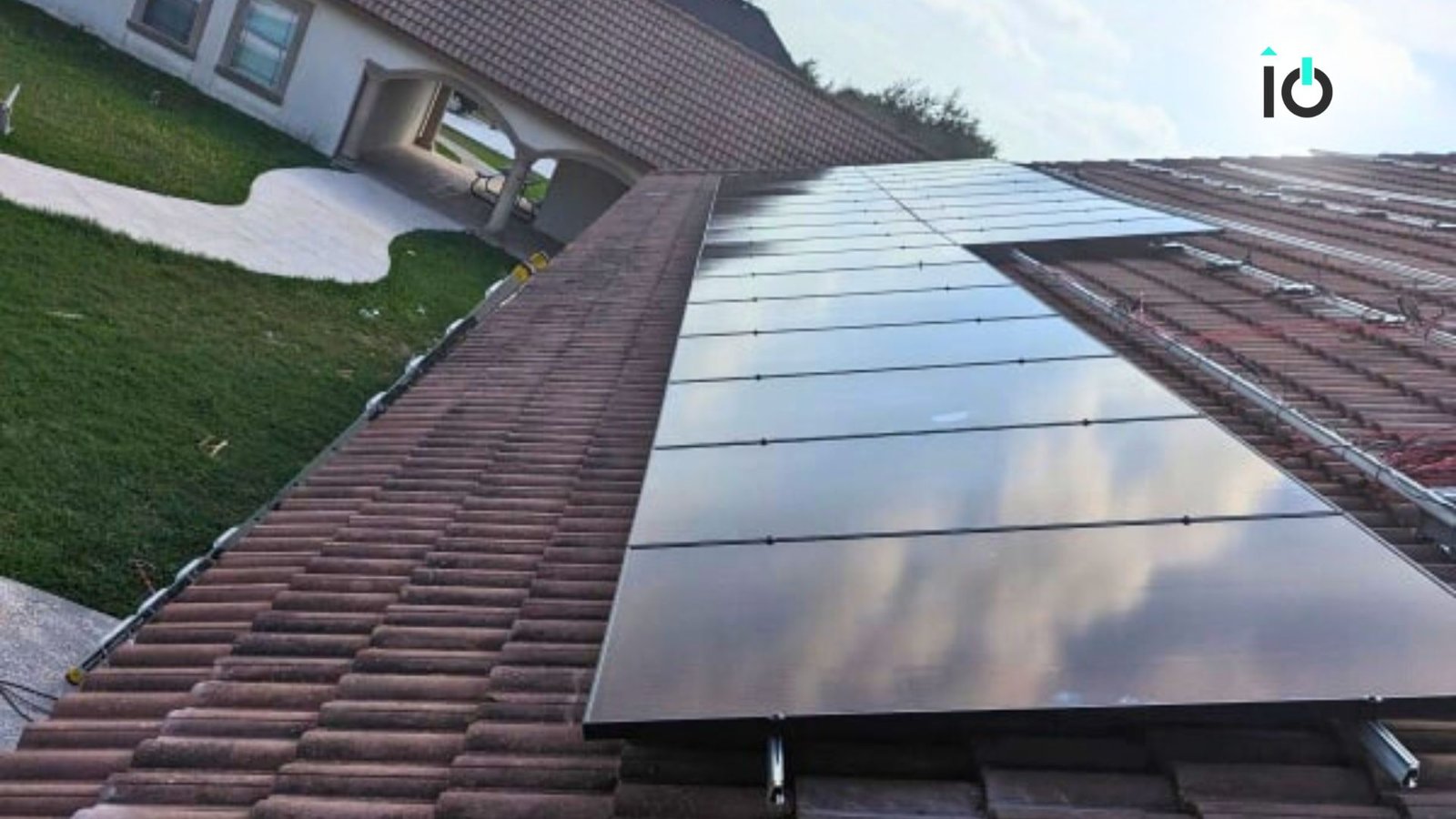 Solar array on a residential roof beside a lawn