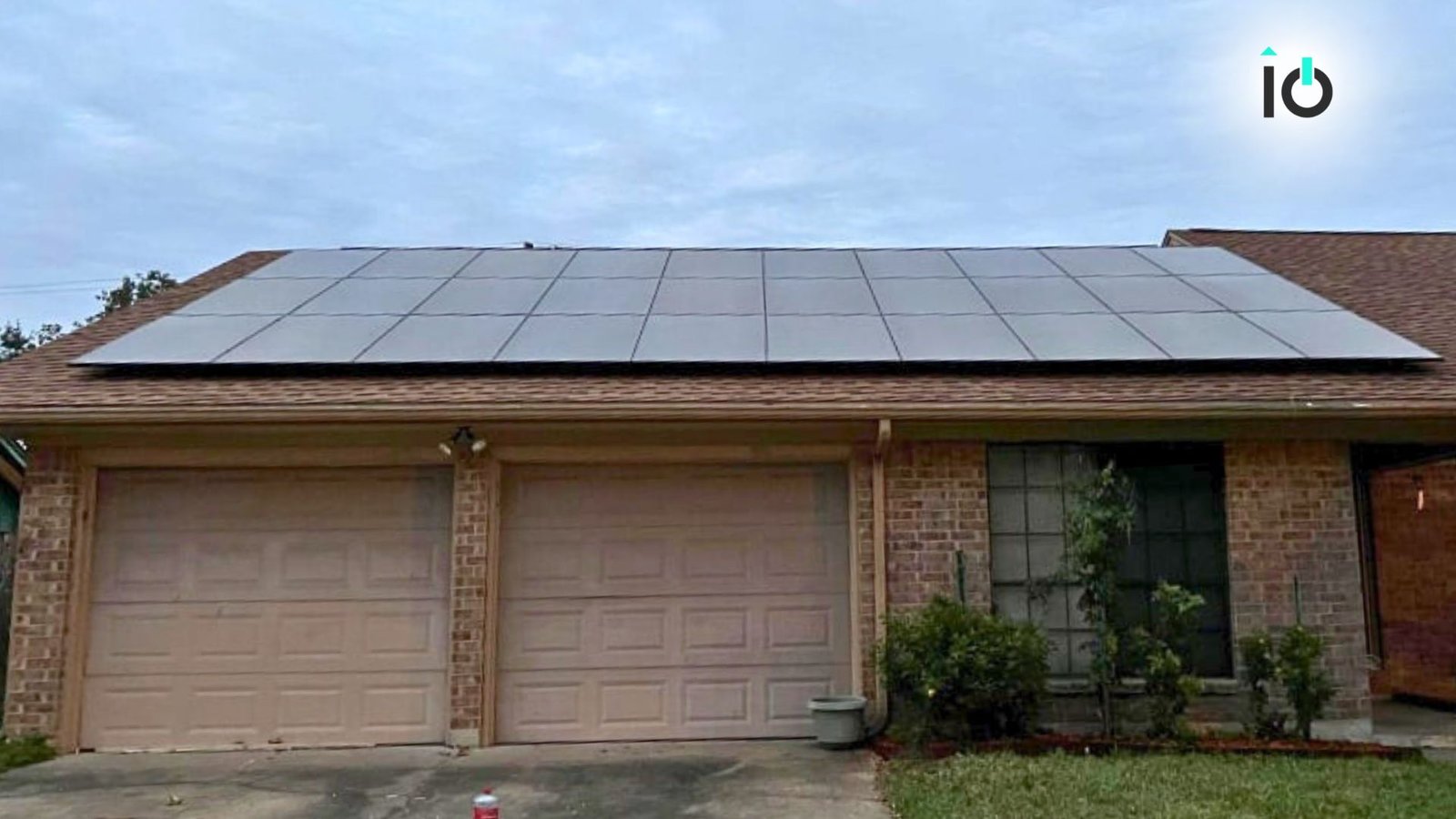 Single-story brick home with a rooftop solar array above the garage