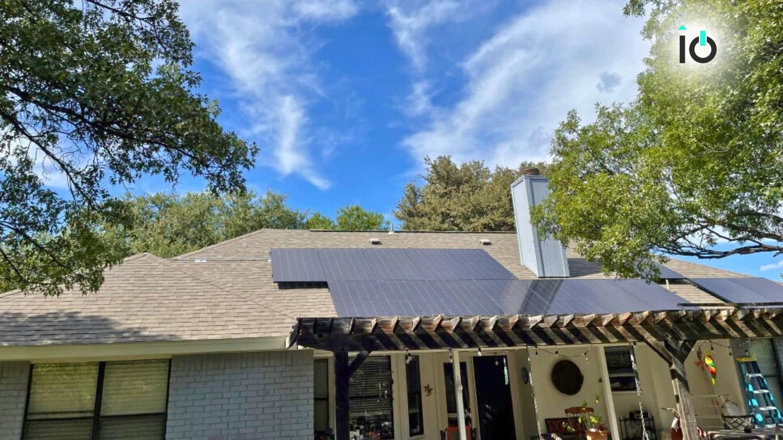 Home with rooftop solar panels behind a garden pergola