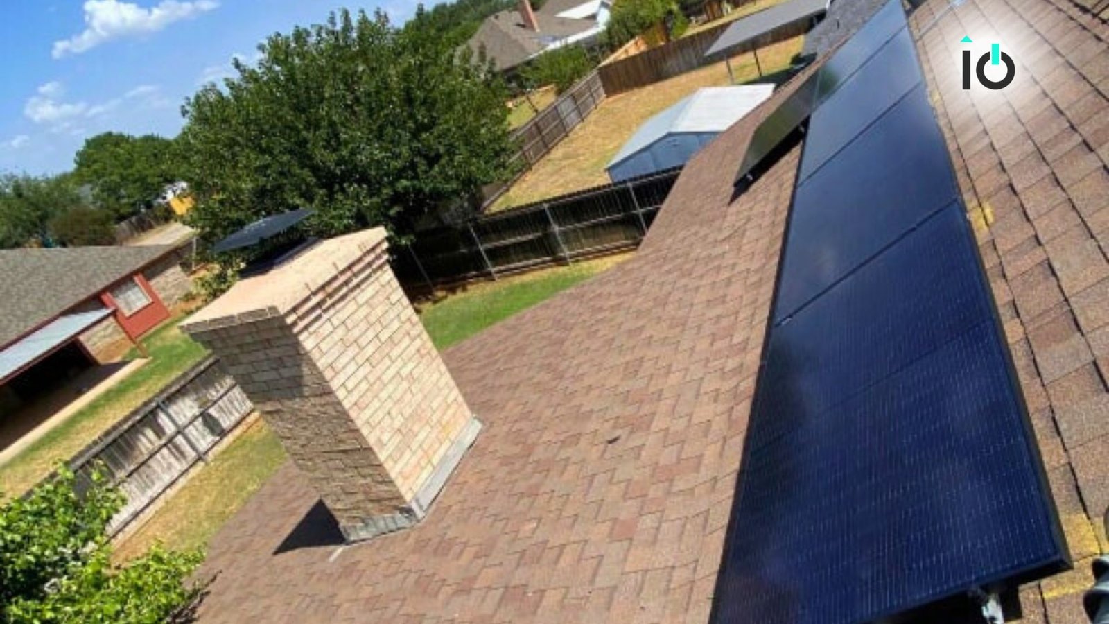 Solar panels on a roof beside a brick chimney
