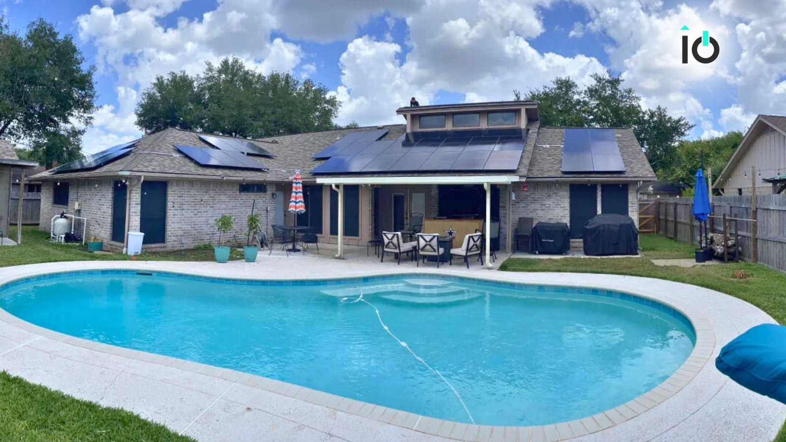Backyard pool beside a home with rooftop solar panels