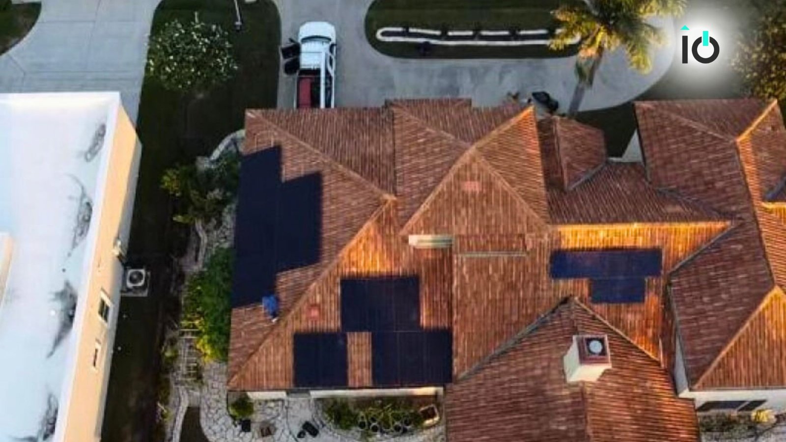 Aerial view of a tile-roof home with solar panels