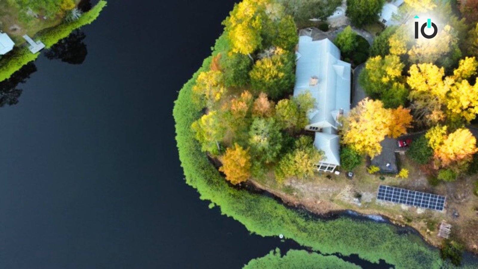 Aerial view of a lakeside property with ground-mounted solar