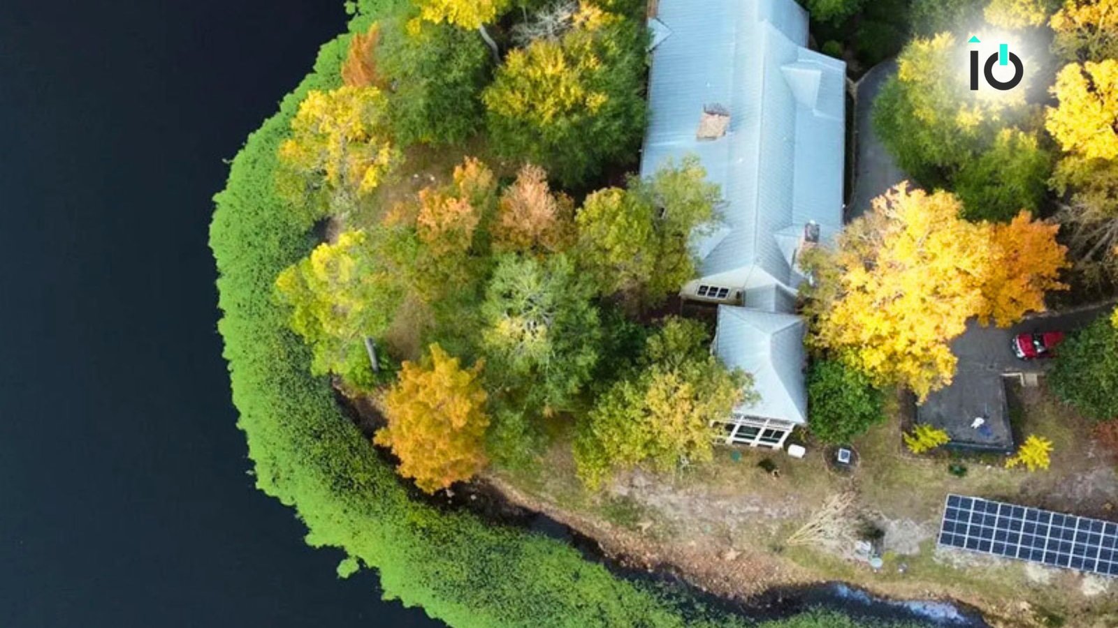 Aerial view of ground-mounted solar panels beside water