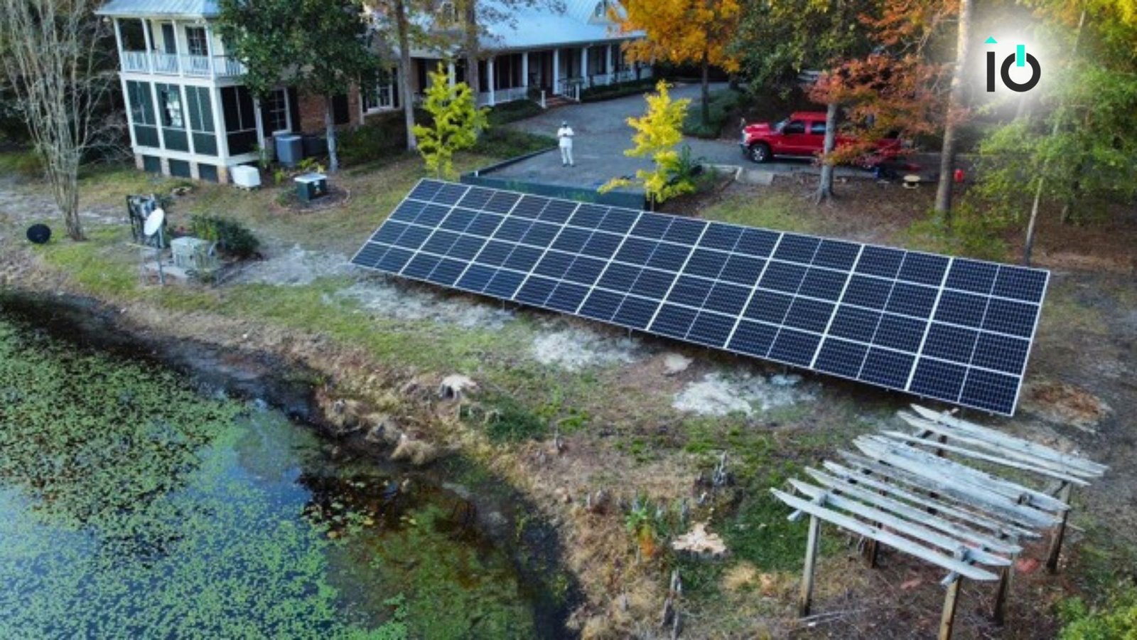 Ground-mounted solar array beside a lakeside home