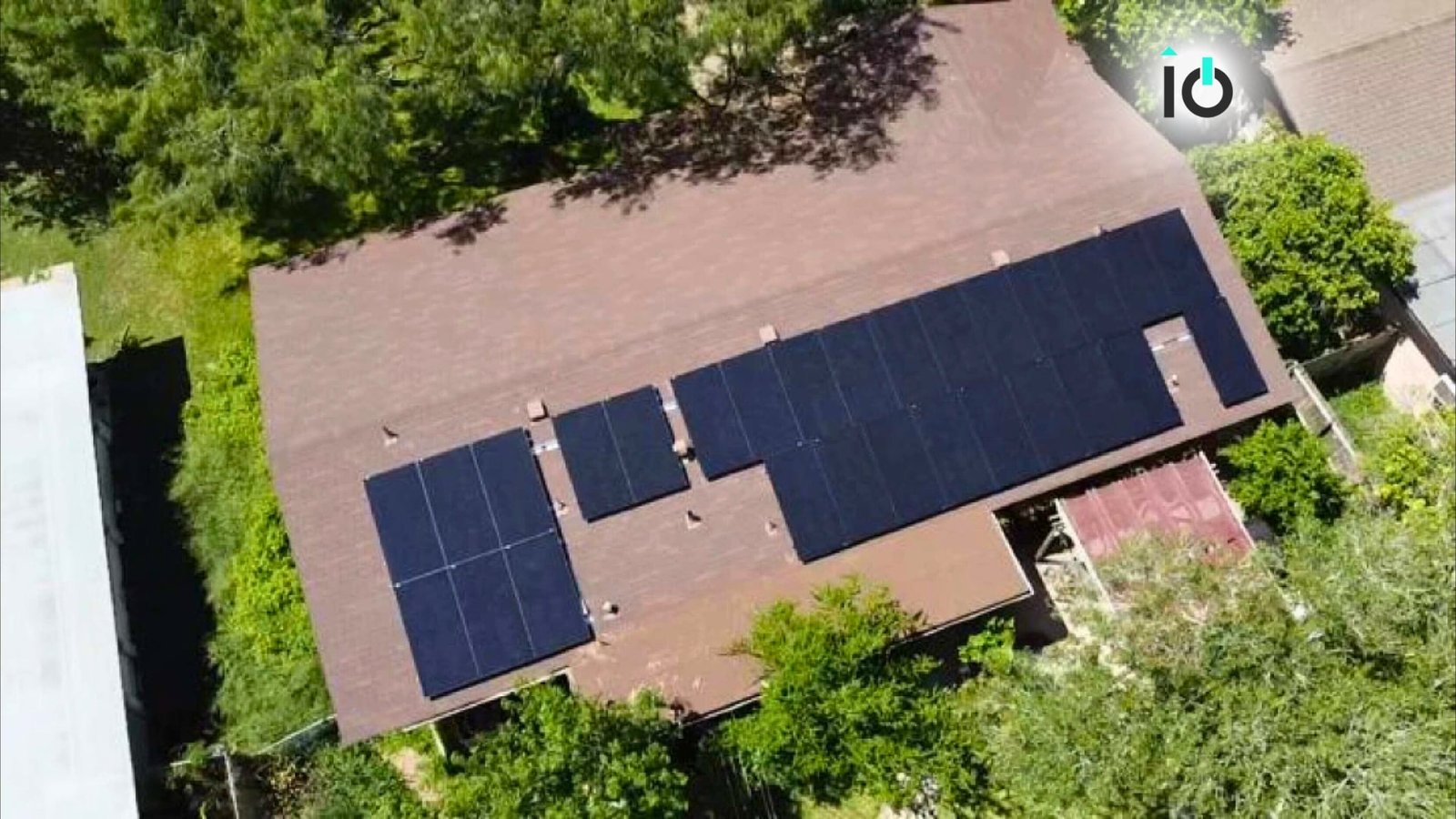 Aerial view of a home with black solar panels on the roof