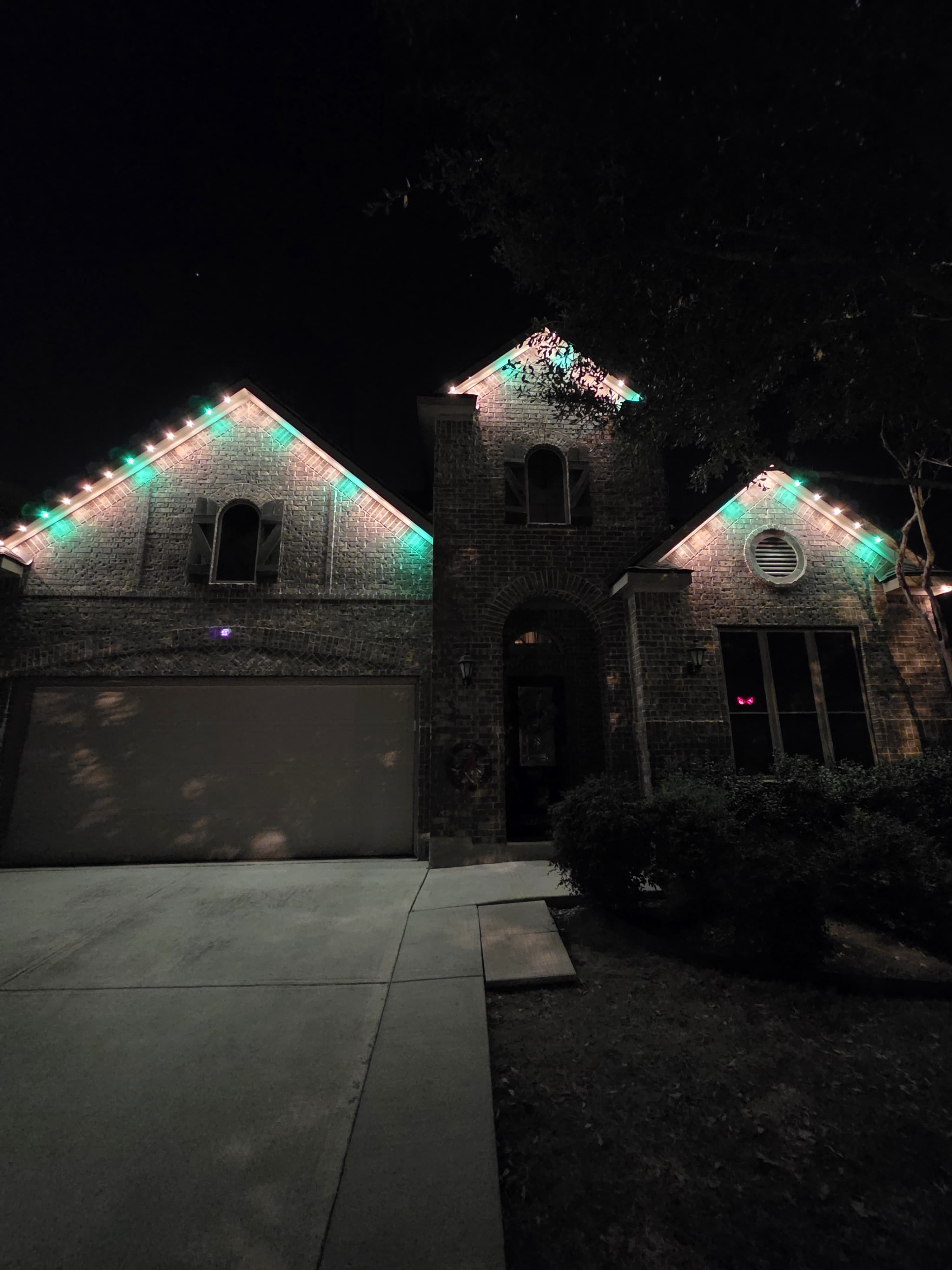 Close view of permanent lights following the peaks of a stone home