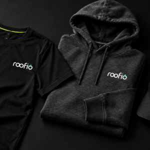 Black roofio tee, hoodie and cap arranged in a flat lay