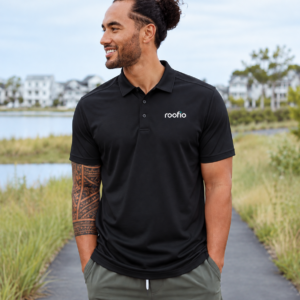 Model wearing the black Roofio Pinnacle Polo with a small Roofio logo on the left chest